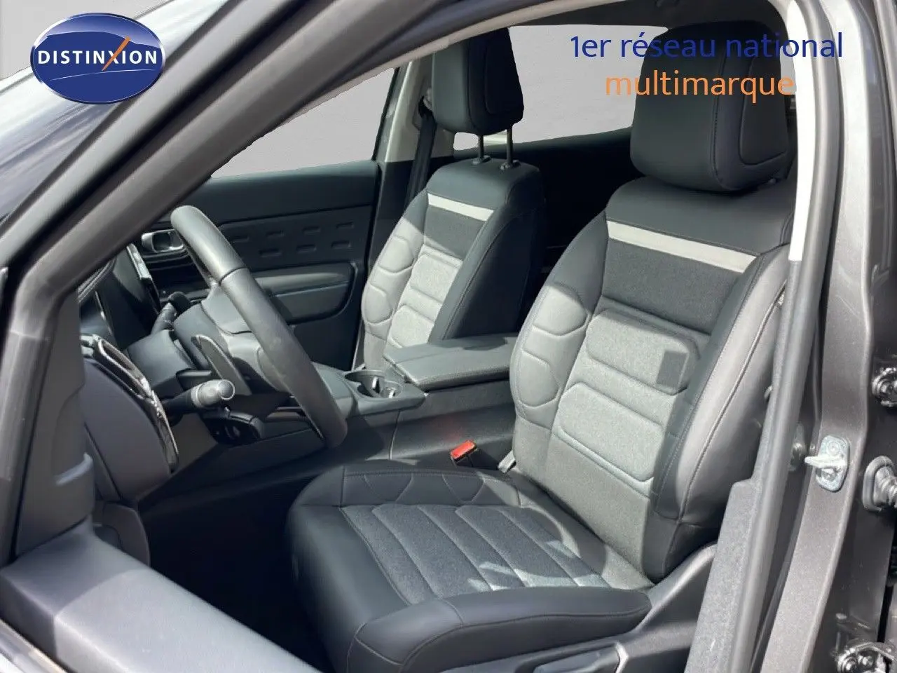 Vue intérieure côté conducteur du Citroën C5 Aircross Hybrid gris platinium, montrant les sièges en tissu et cuir noir.