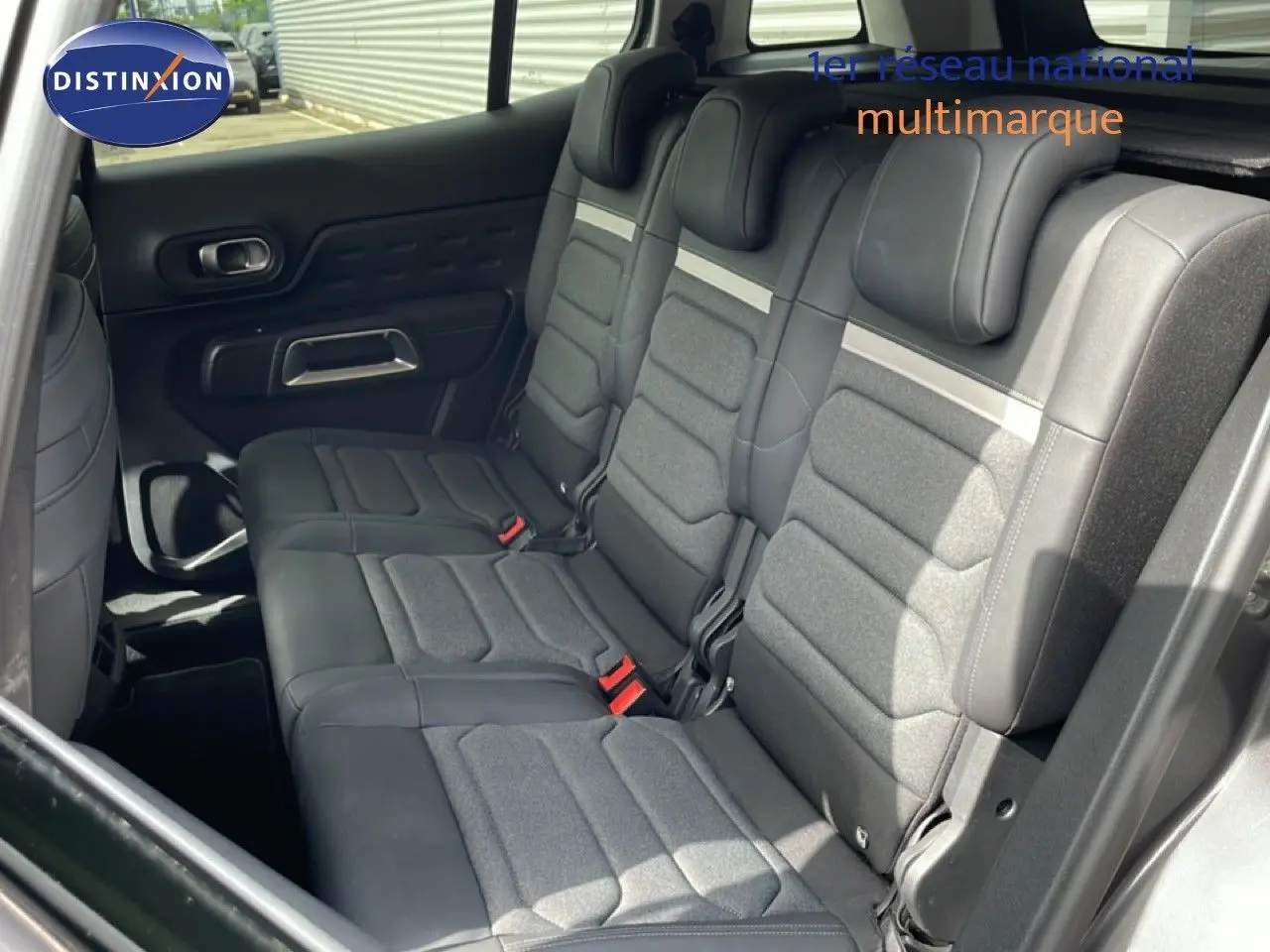 Vue intérieure côté droit montrant la banquette arrière en tissu et cuir noir du Citroën C5 Aircross Hybrid 2025.