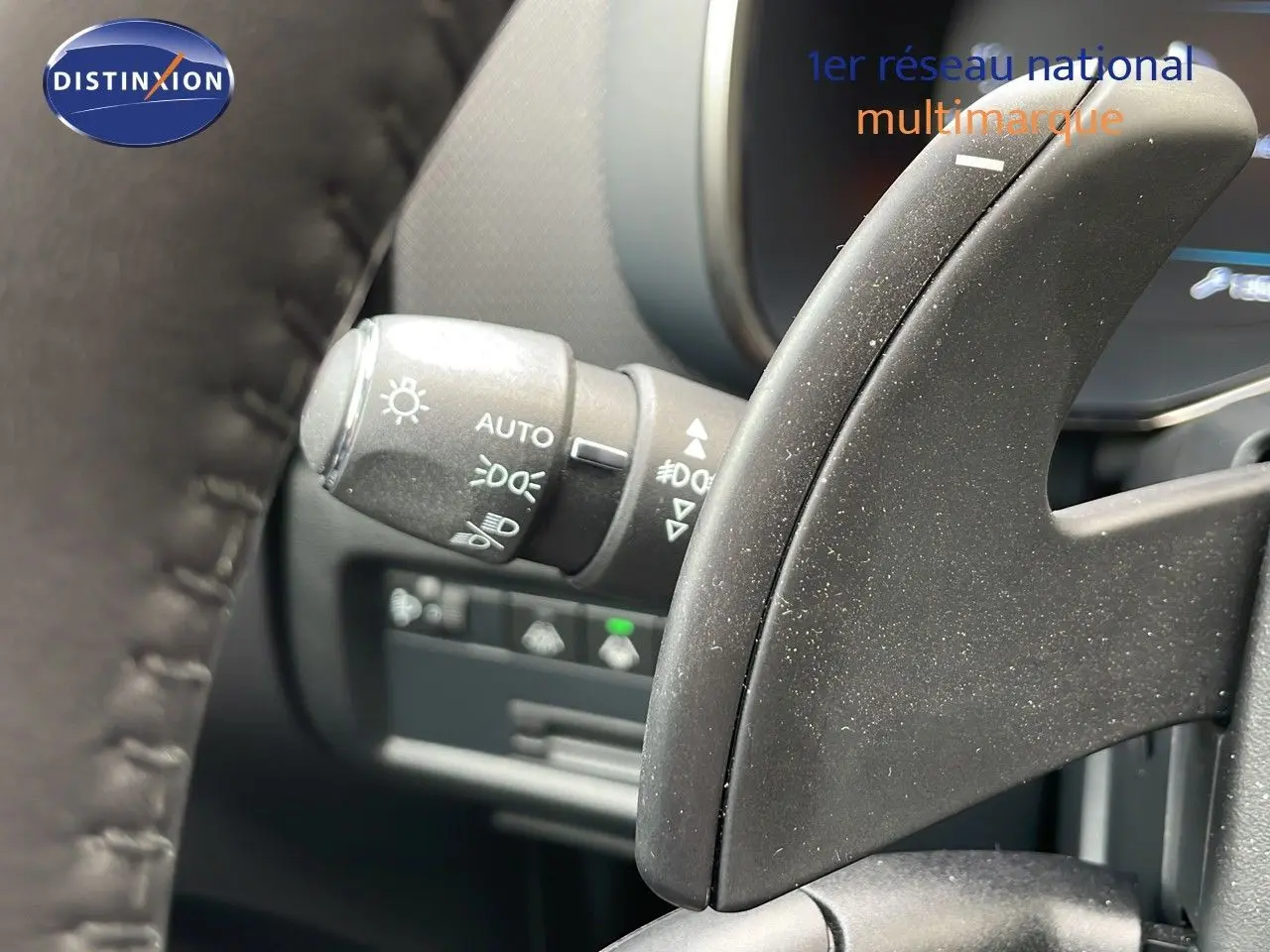 Détail intérieur montrant la commande des phares et le levier de vitesse au volant d’un Citroën C5 Aircross Hybrid 2025.