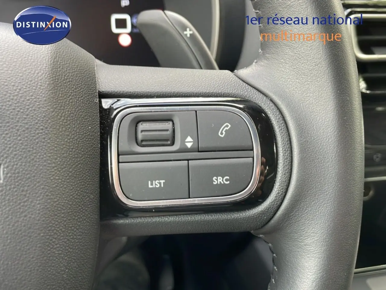 Gros plan sur les commandes gauche du volant en cuir noir du Citroën C5 Aircross Hybrid gris platinium 2025.