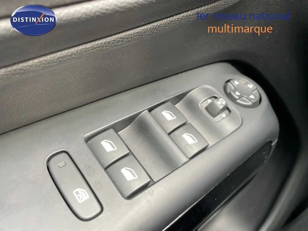 Gros plan sur les commandes des vitres électriques côté conducteur d'une Citroën C5 Aircross Hybrid 2025, intérieur noir.