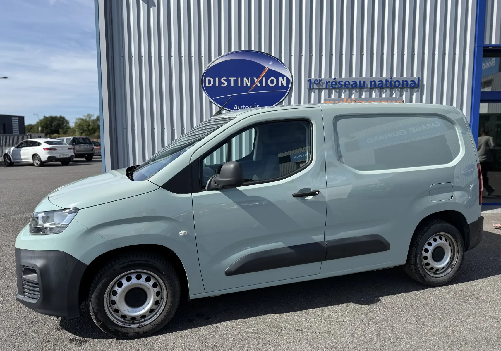Vue de profil côté gauche d’un Citroën Berlingo FGN beige 2019 avec protections noires sur les portières et jantes acier.