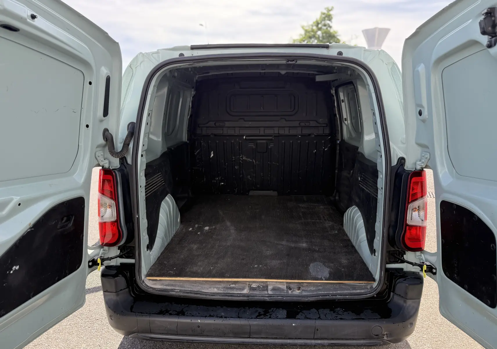 Vue arrière ouverte du Citroën Berlingo FGN beige 2019, montrant l’espace de chargement vide et les portes battantes.