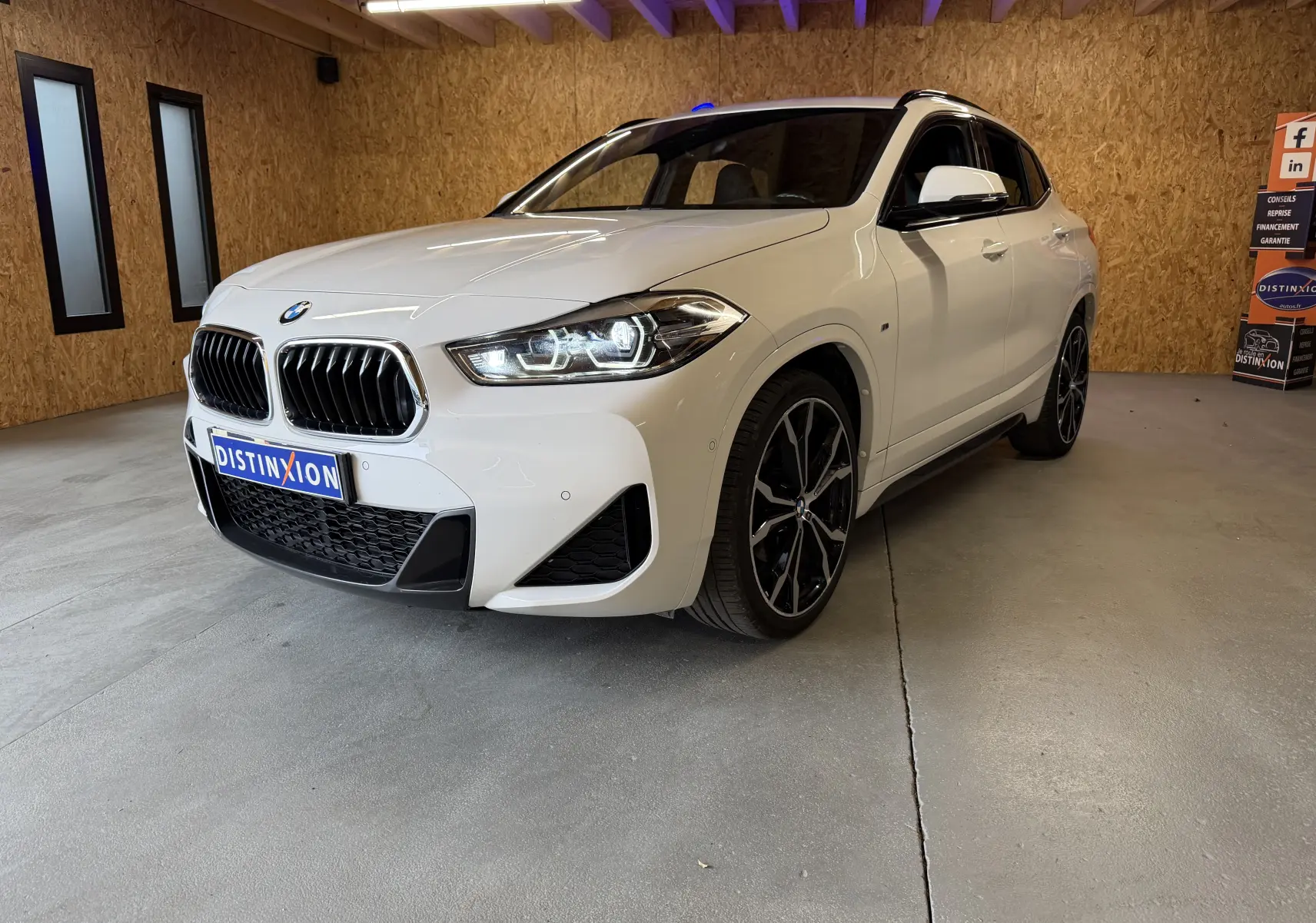 BMW X2 sDrive18d blanc vue 3/4 avant droit avec jantes alu noires et calandre double haricot M Sport.