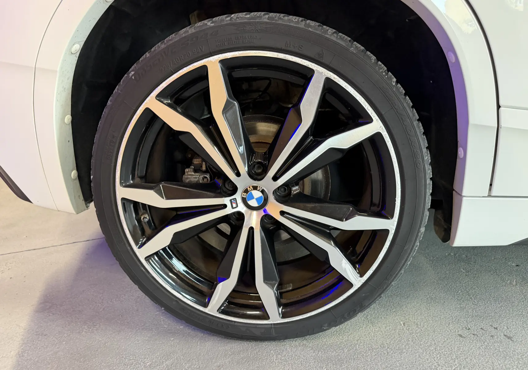Gros plan sur la jante alu 20 pouces bicolore du côté avant droit d'une BMW X2 blanche 2023.