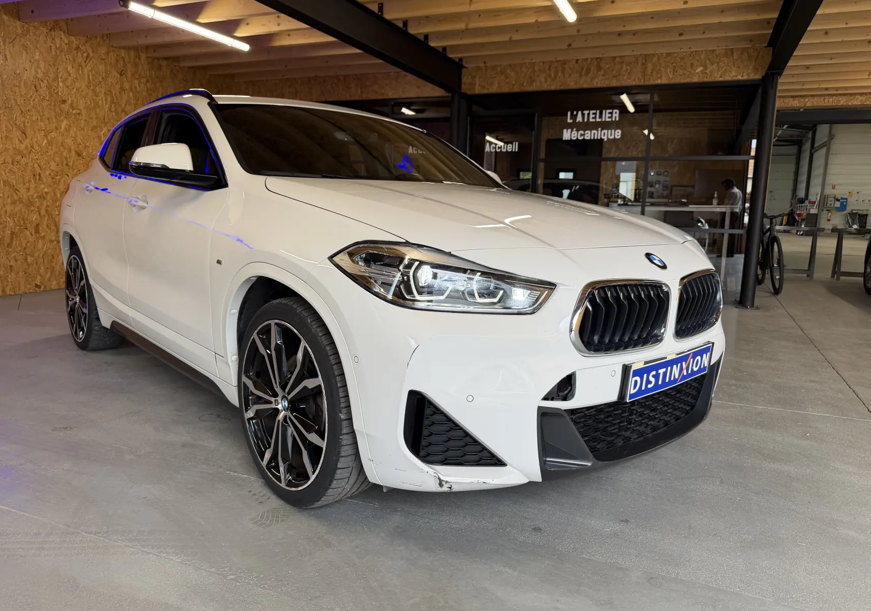 BMW X2 sDrive18d blanc vue 3/4 avant droit, avec jantes alu noires et calandre double haricot M Sport.