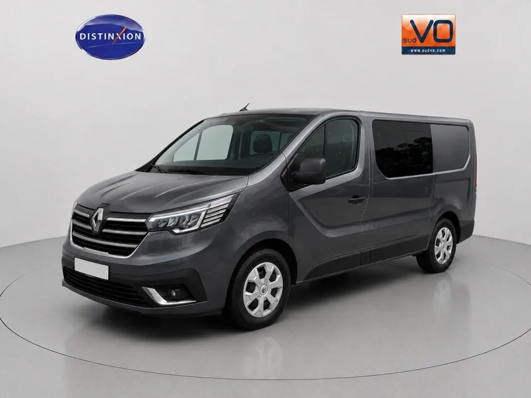 Renault Trafic Fourgon gris foncé en 3/4 avant droit, avec vitres surteintées et porte latérale visible.