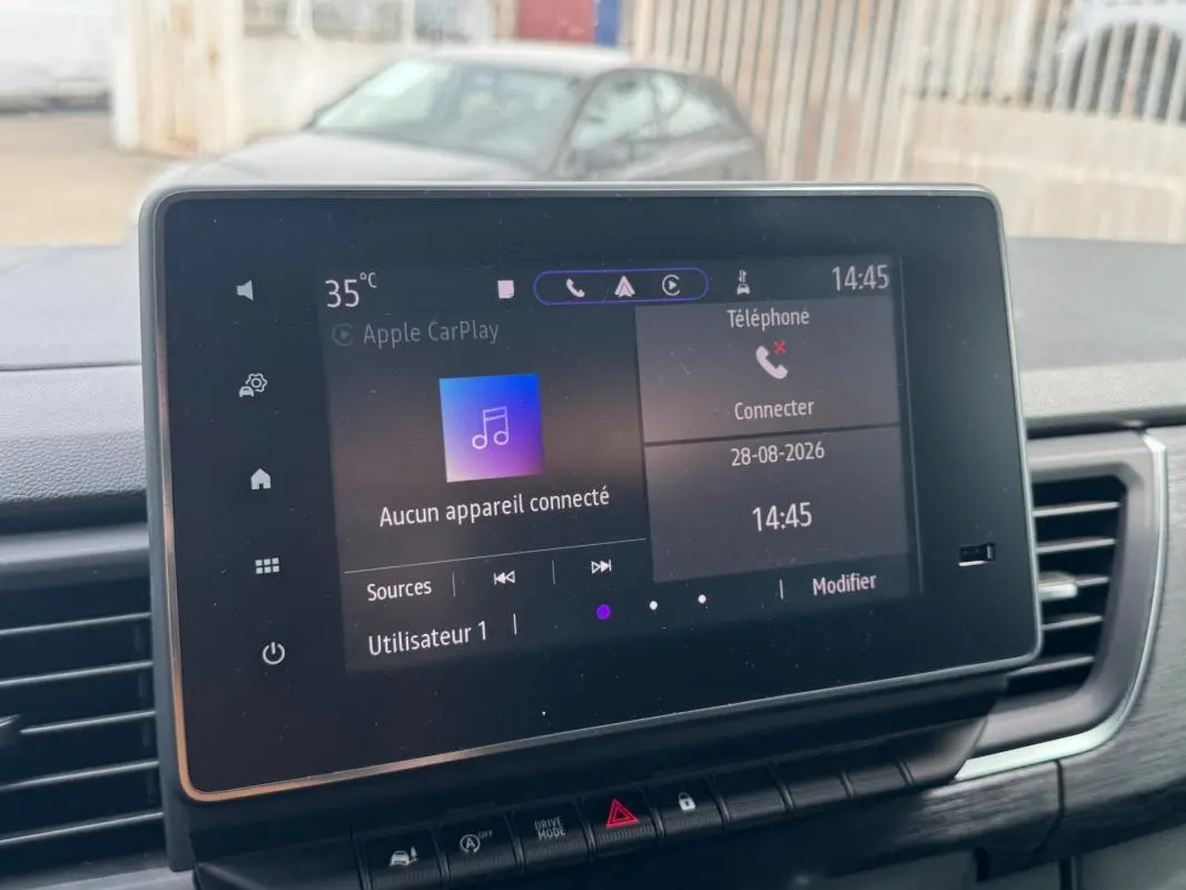 Écran tactile central du Renault Trafic Fourgon gris foncé, vue intérieure du tableau de bord avec commandes visibles.