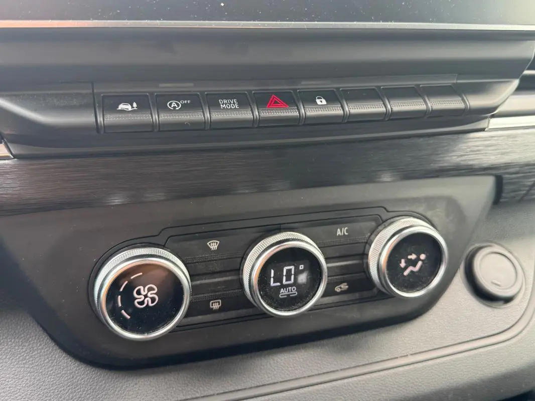 Gros plan sur la console centrale du Renault Trafic Fourgon 2024, montrant les commandes de climatisation et les boutons de fonction.