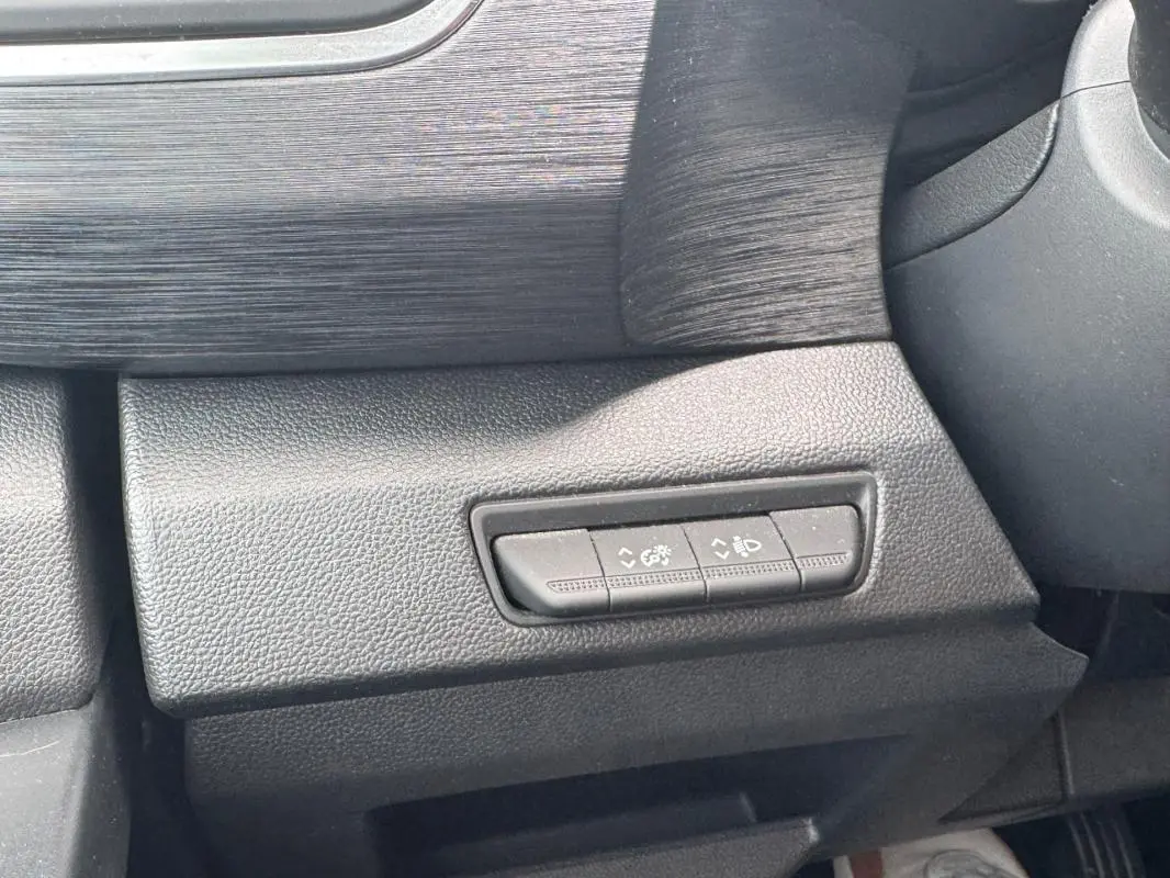 Détail des commandes de réglage des feux et du tableau de bord sur Renault Trafic Fourgon gris foncé, vue intérieure côté conducteur.