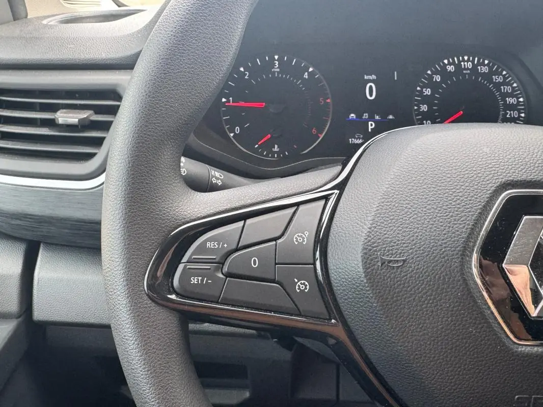 Vue rapprochée du volant Renault Trafic Fourgon 2024 avec commandes de régulateur de vitesse et tableau de bord numérique.