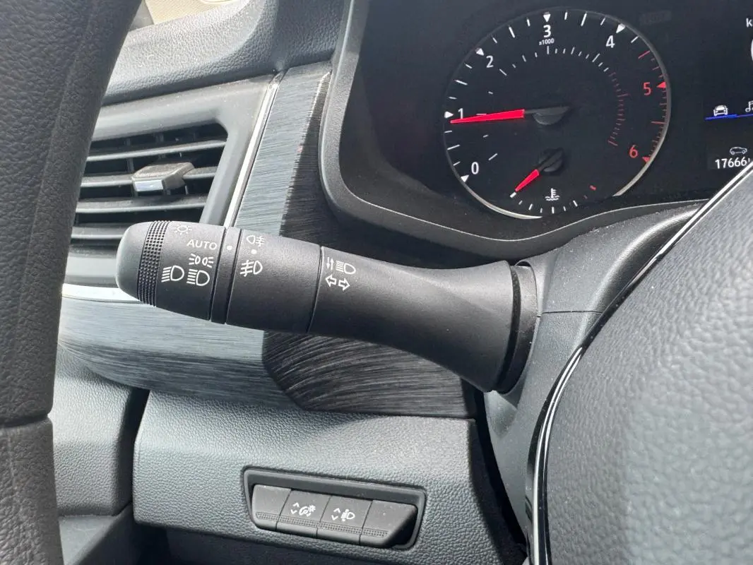 Gros plan sur la commande des feux et clignotants à gauche du volant dans l'habitacle du Renault Trafic Fourgon gris foncé.