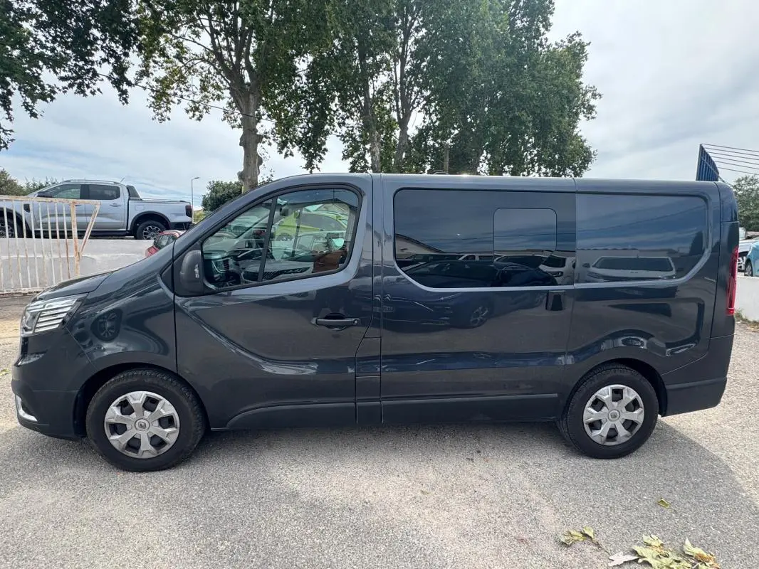 Profil côté gauche du Renault Trafic Fourgon gris foncé 2024 avec porte latérale et vitres surteintées.