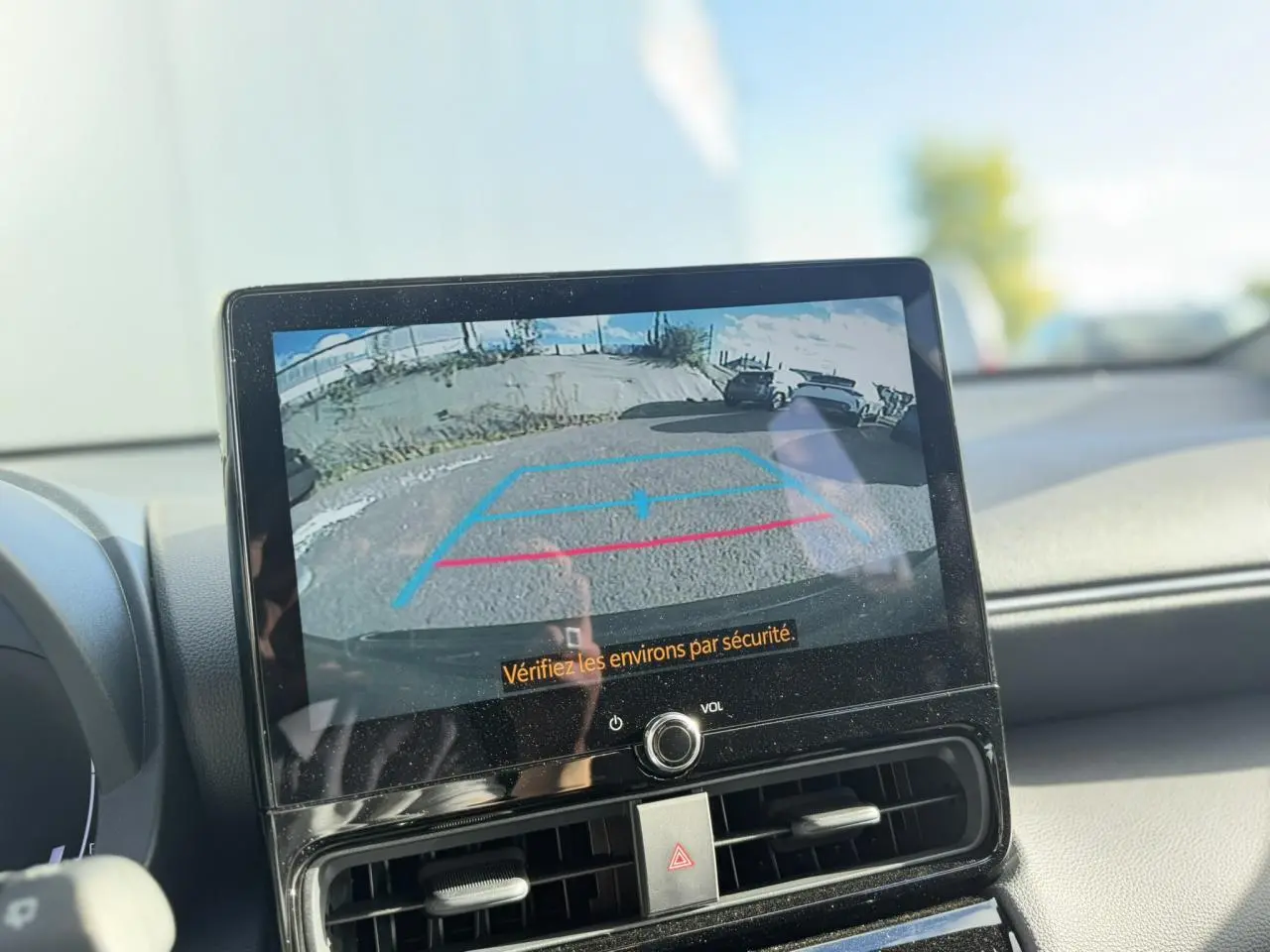 Écran tactile intérieur montrant la caméra de recul d’une Toyota Yaris Cross 1.5 Hybrid gris Atlas.