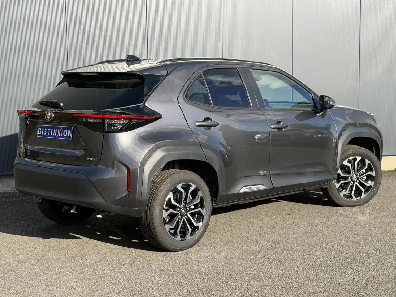 Toyota Yaris Cross gris Atlas vue 3/4 arrière droit, avec jantes alliage 17 pouces et toit noir contrasté.