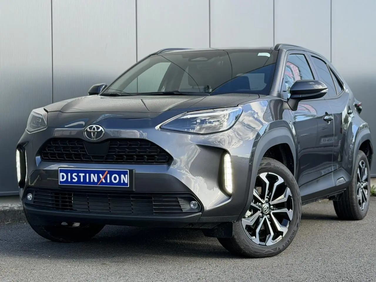 Toyota Yaris Cross gris Atlas vue 3/4 avant droit avec feux LED verticaux et jantes alliage 17 pouces.