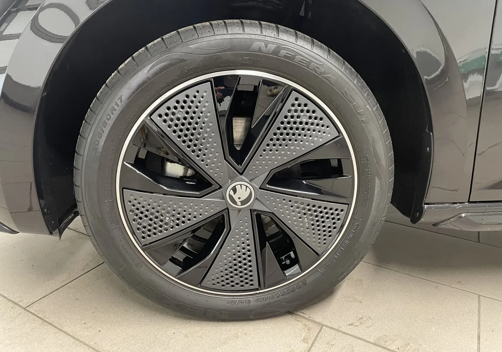 Gros plan sur la roue avant gauche noire métallisée du Skoda Scala 1.5 TSI 150 DSG7 Monte-Carlo avec jante au design perforé.