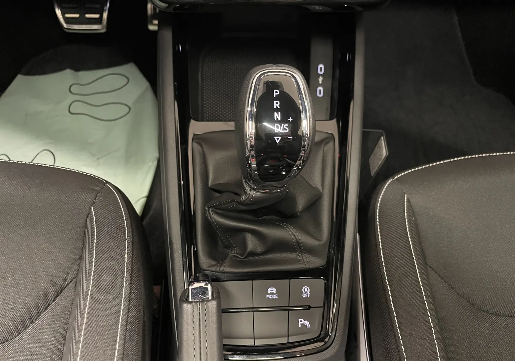 Vue rapprochée de la console centrale de la Skoda Scala 2025, montrant le levier de vitesses automatique et les sièges noirs.