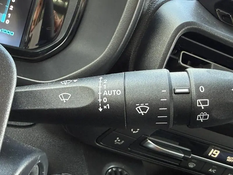Gros plan sur la commande d’essuie-glace du Citroën Berlingo 2025, intérieur noir avec détails fonctionnels blancs.