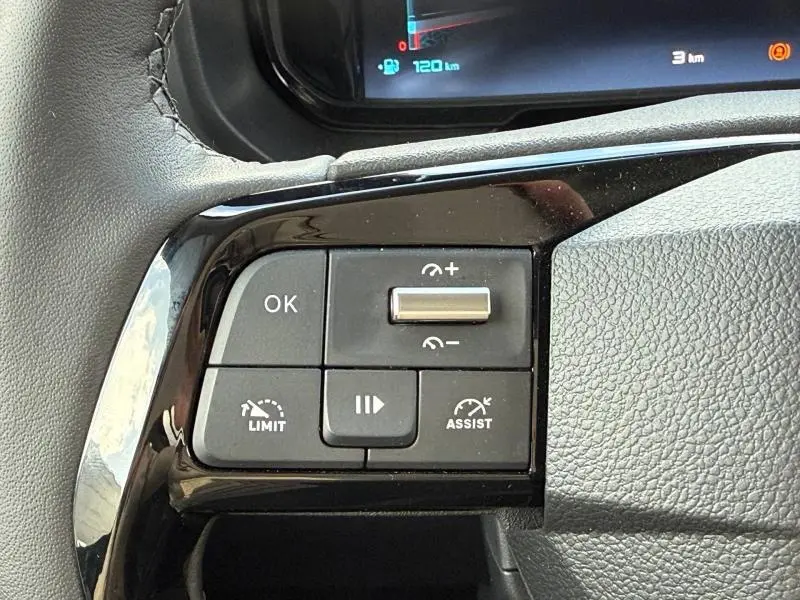 Gros plan sur les commandes noires du volant multifonction du Citroën Berlingo 2025, finition Urban Grey.