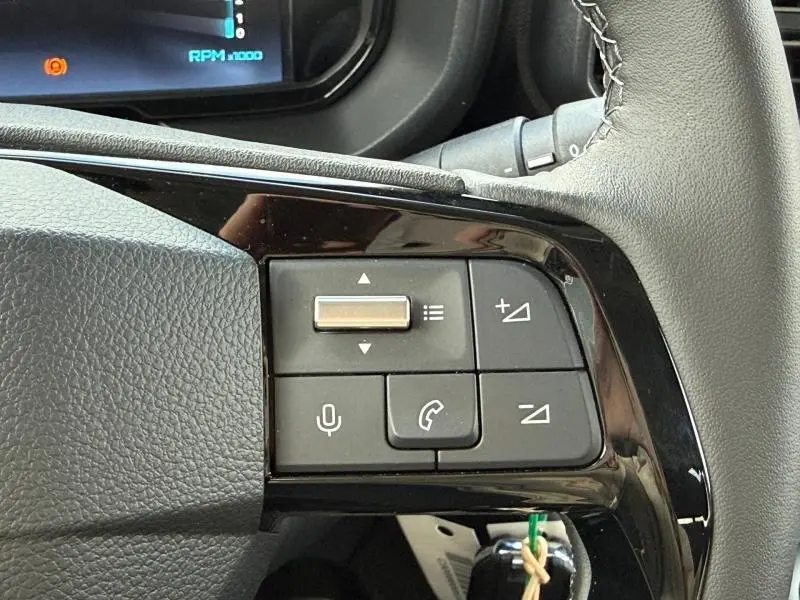 Gros plan sur les commandes multifonctions du volant du Citroën Berlingo 2025 en Sirkka Green, côté gauche.