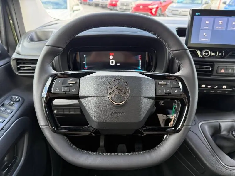 Vue centrée sur le volant multifonction noir du Citroën Berlingo 2025 avec tableau de bord numérique et écran tactile.