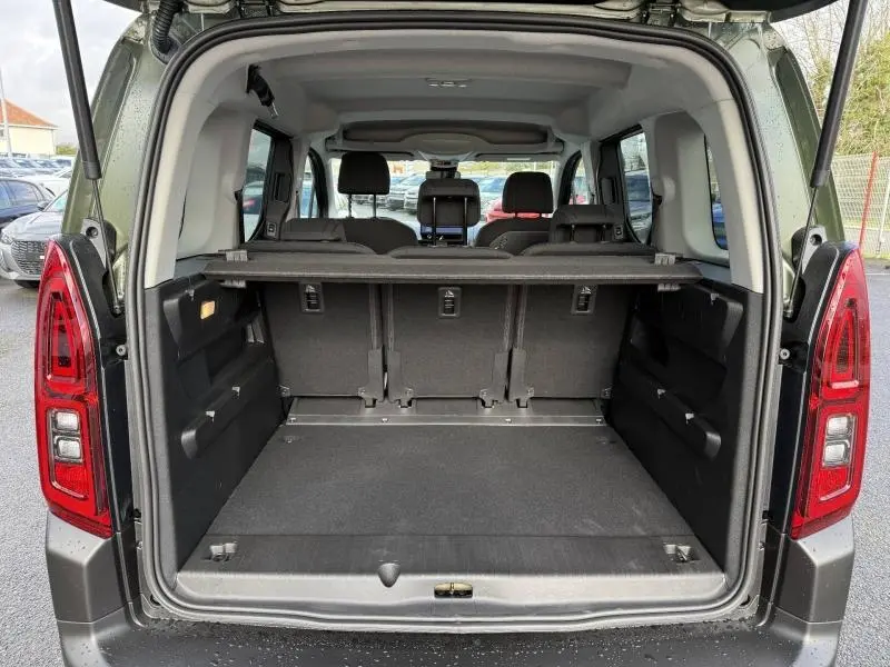 Coffre ouvert vu de l'arrière d'un Citroën Berlingo Sirkka Green avec banquette arrière 3 places et tablette cache-bagages.