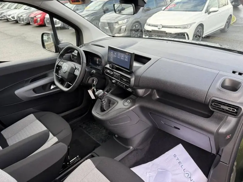 Vue intérieure côté conducteur du Citroën Berlingo 2025 avec tableau de bord noir et écran tactile central.