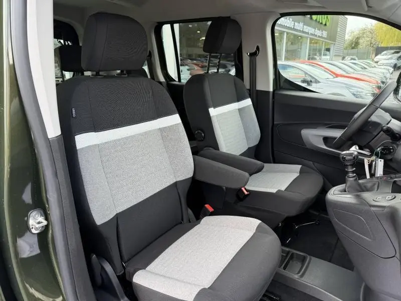 Vue intérieure côté conducteur du Citroën Berlingo Sirkka Green, sièges bi-ton gris et noir avec accoudoir central.