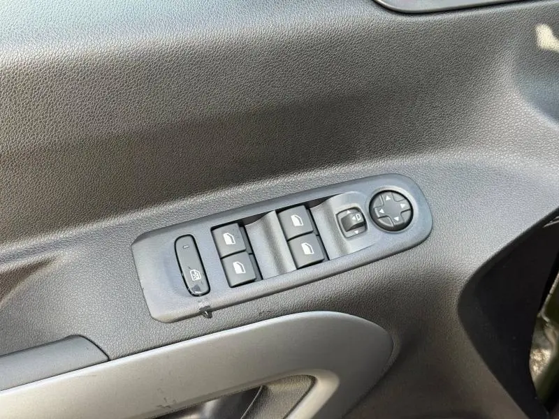 Gros plan sur les commandes des vitres électriques et rétroviseurs côté conducteur du Citroën Berlingo Sirkka Green.