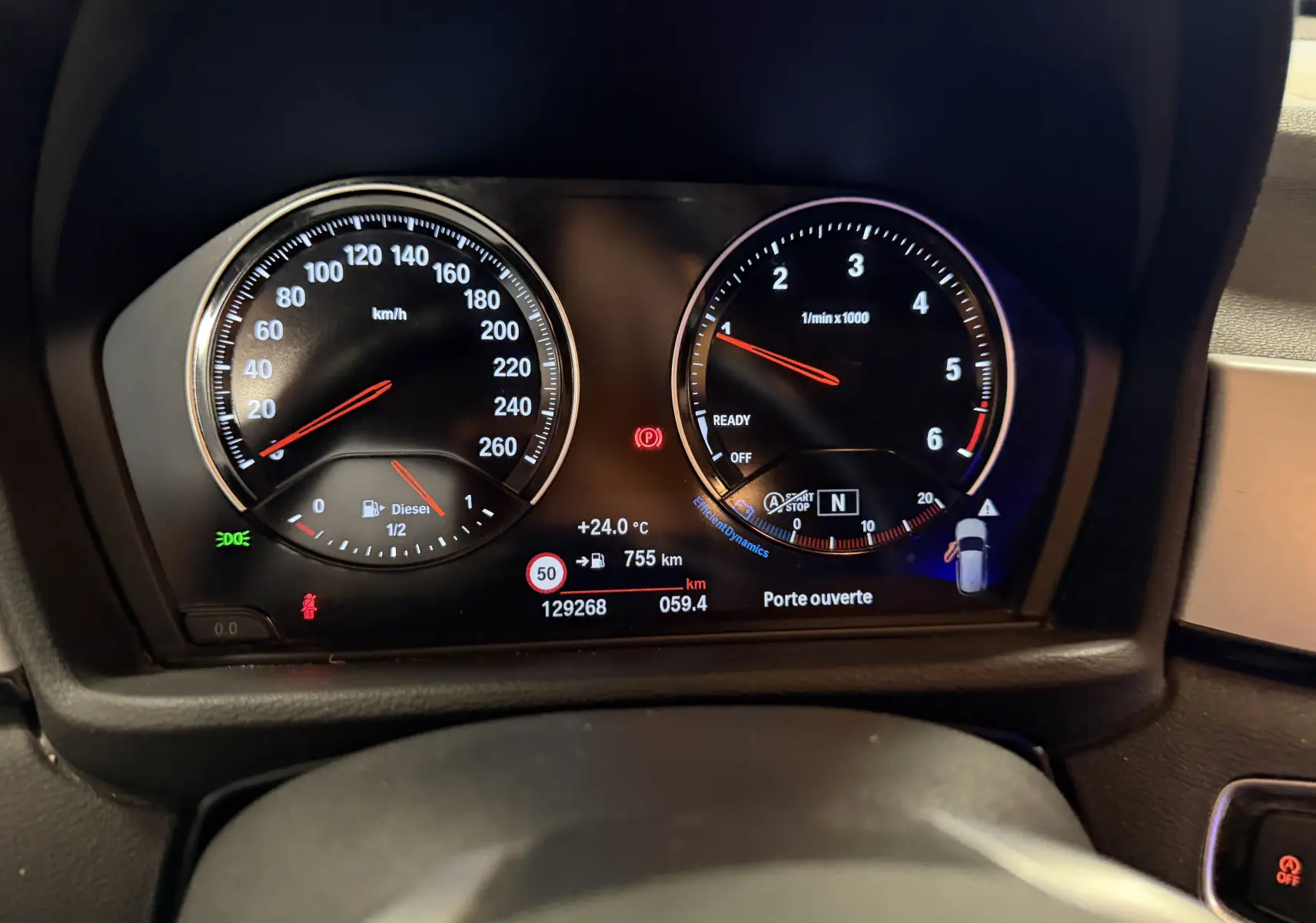 Vue rapprochée du tableau de bord du BMW X1 noir 2019, affichant compteurs et indicateurs numériques.