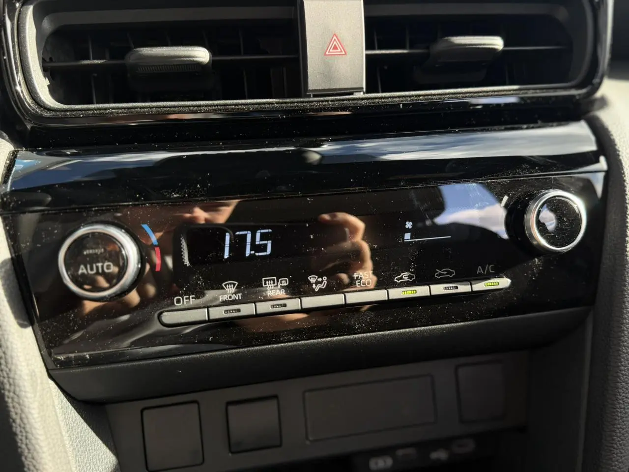 Gros plan sur la commande de climatisation automatique noire du Toyota Yaris Cross 2026, affichant 17,5°C.
