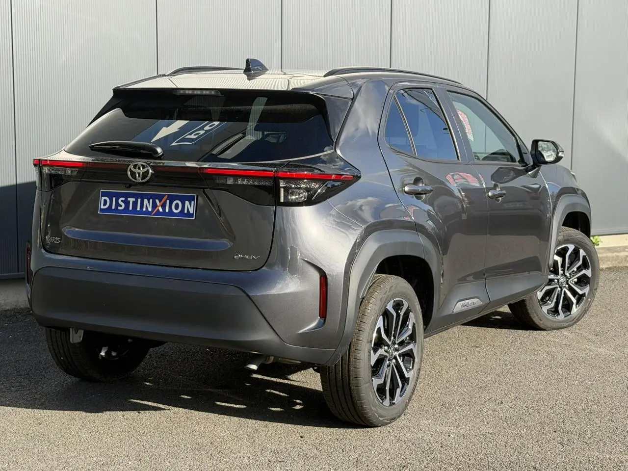 Vue 3/4 arrière droite d'une Toyota Yaris Cross 2026 gris Atlas avec jantes alliage 17 pouces et antenne aileron de requin.