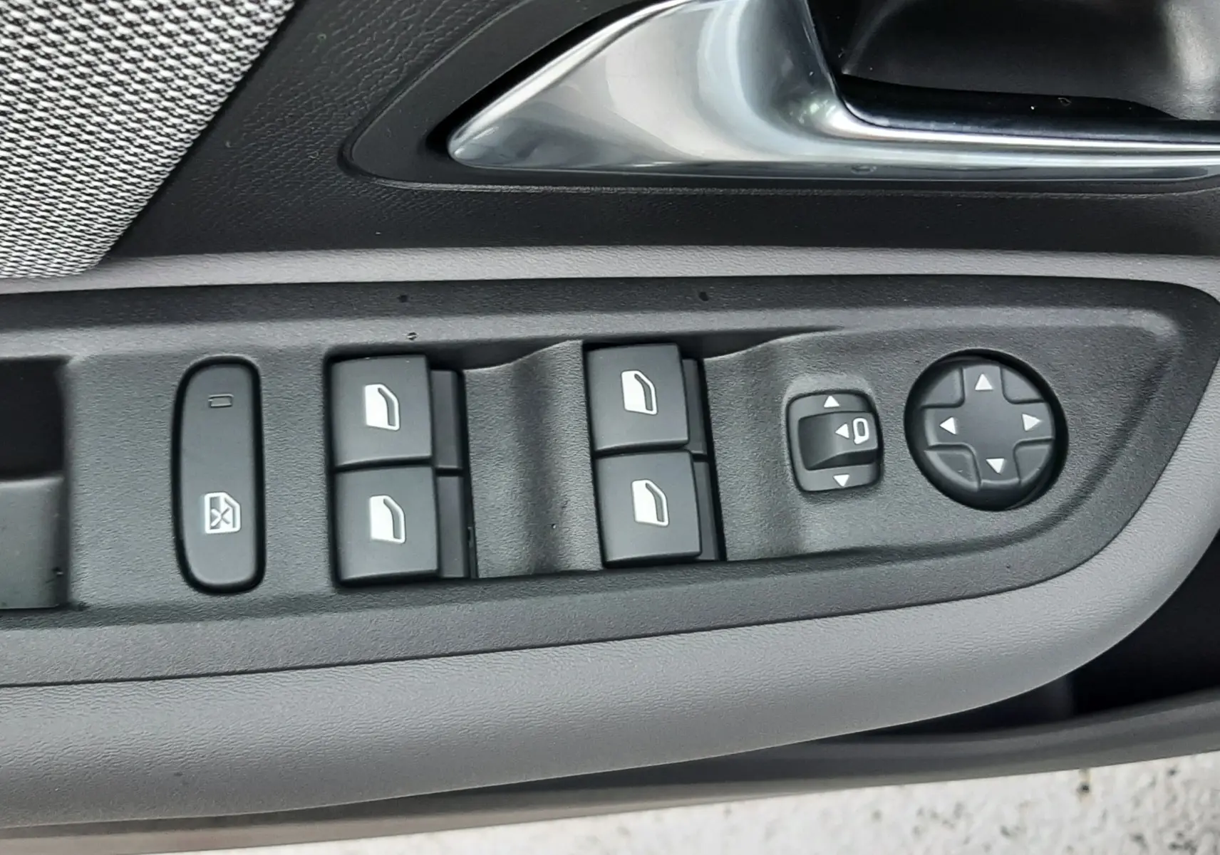 Gros plan sur la commande des vitres et rétroviseurs côté conducteur de la Citroën C4 blanche, version hybride 2026.