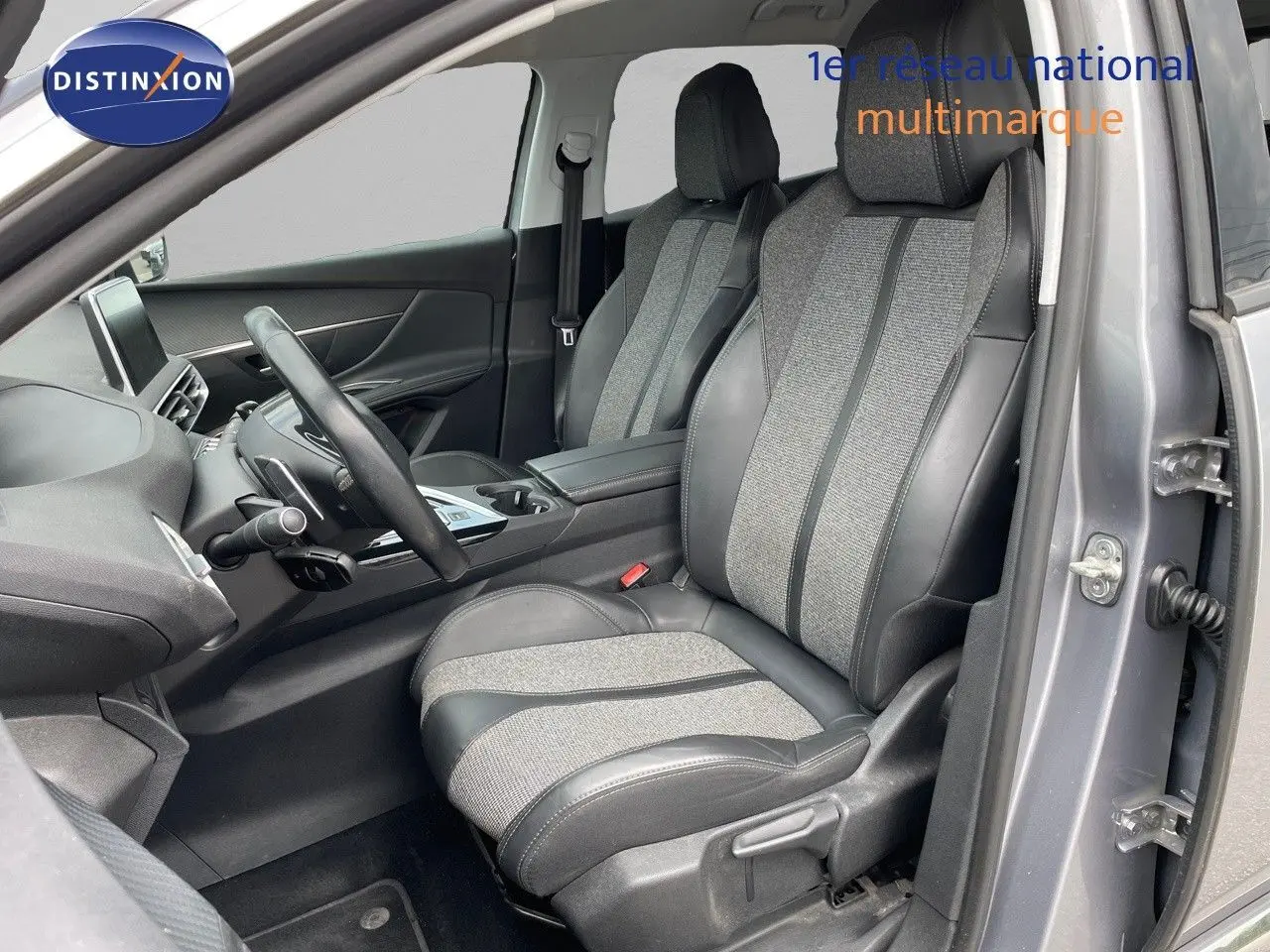 Intérieur avant droit du Peugeot 3008 gris Artense, sièges en cuir et tissu gris, volant multifonction visible.