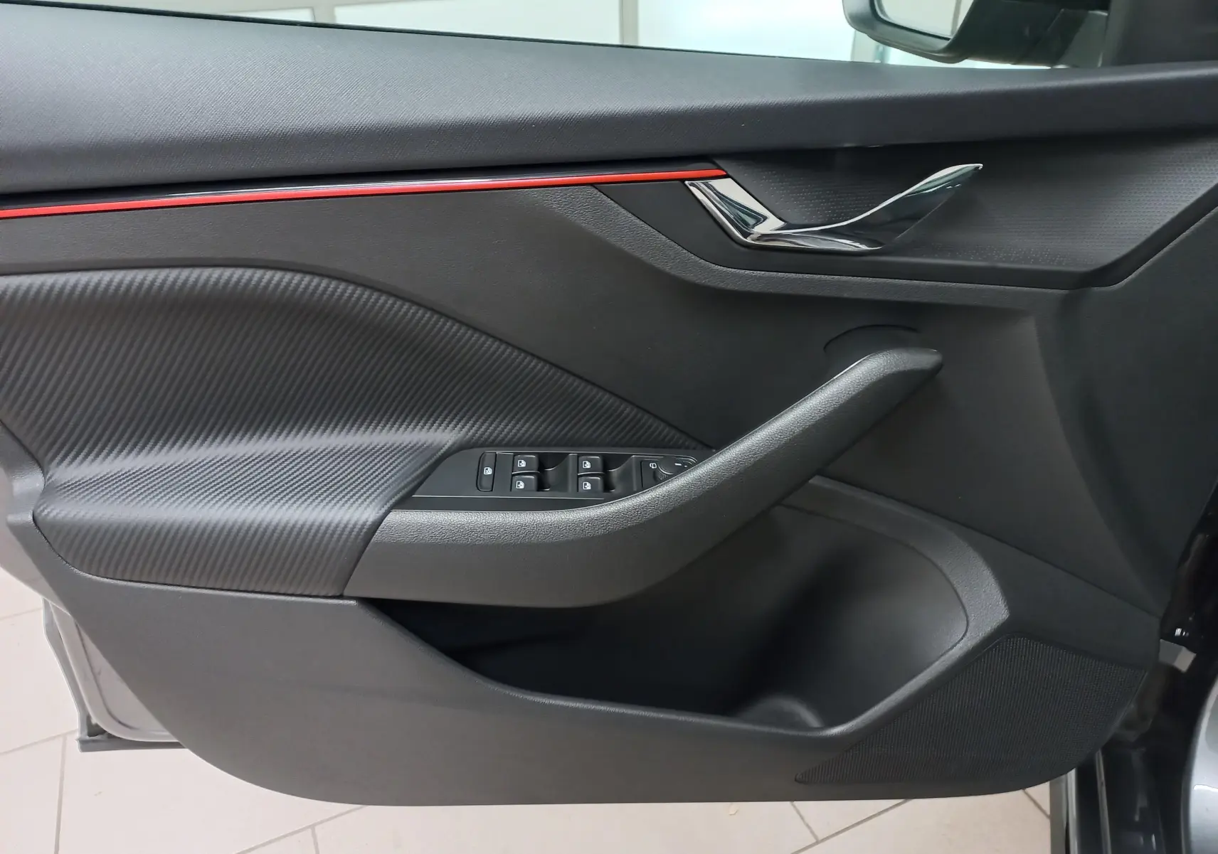 Intérieur côté gauche de la porte SKODA SCALA 1.5 TSI 150 DSG7 Monte-Carlo avec insert carbone et bande rouge décorative