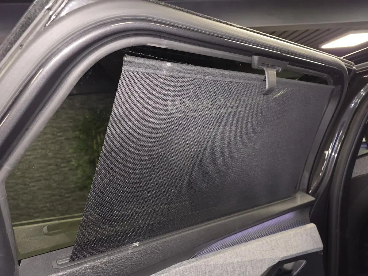 Vue intérieure sur la portière arrière droite du Peugeot 5008 gris avec store pare-soleil déployé.