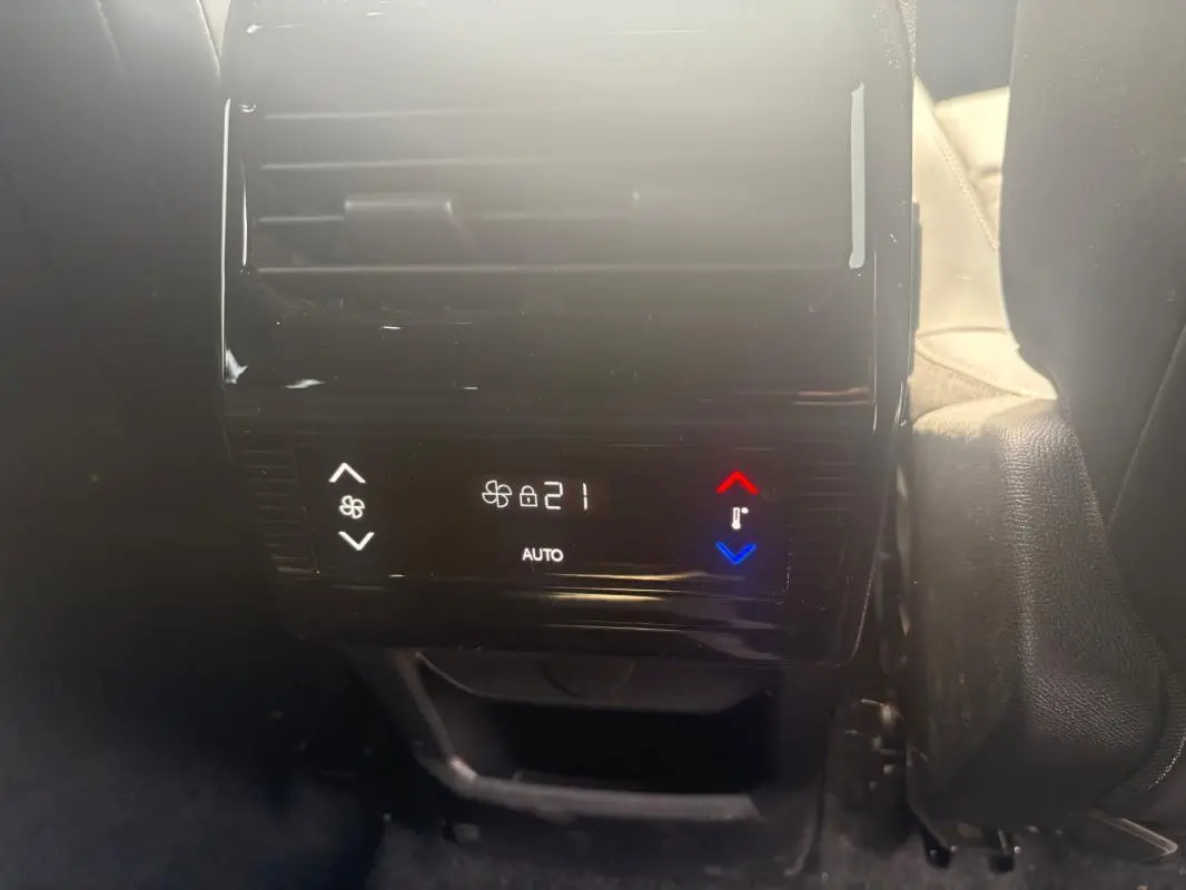 Détail de la commande de climatisation arrière digitale du Peugeot 5008 Hybrid noir, affichant 21°C en mode automatique.