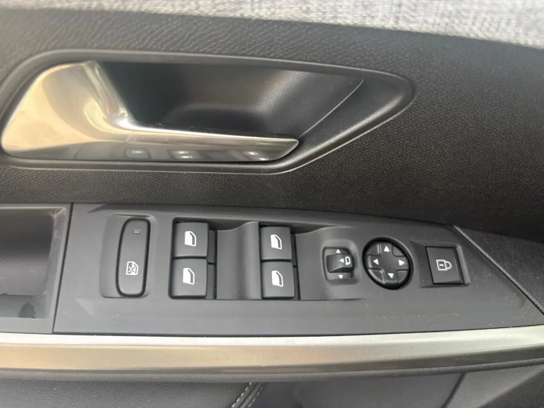 Détail des commandes de porte côté gauche du Peugeot 5008 Hybrid 2025 en noir, avec boutons de vitres et rétroviseurs.