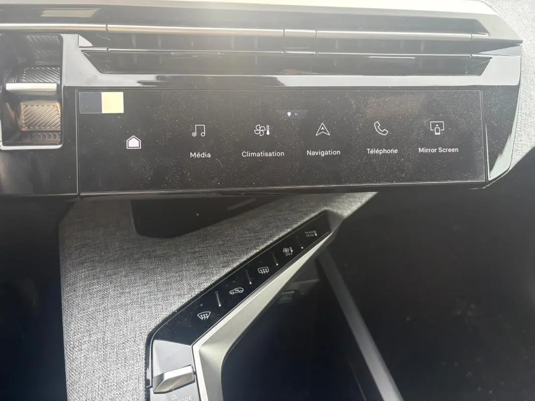 Vue rapprochée de la console centrale intérieure du Peugeot 5008 2025 Allure hybride, avec écran tactile et commandes modernes.