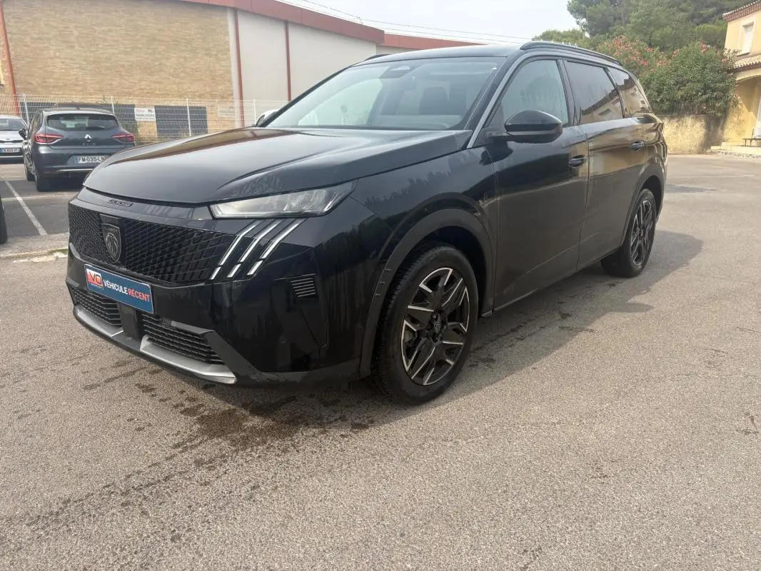Peugeot 5008 Hybrid noir vue 3/4 avant droit, calandre noire avec signature lumineuse verticale distinctive.