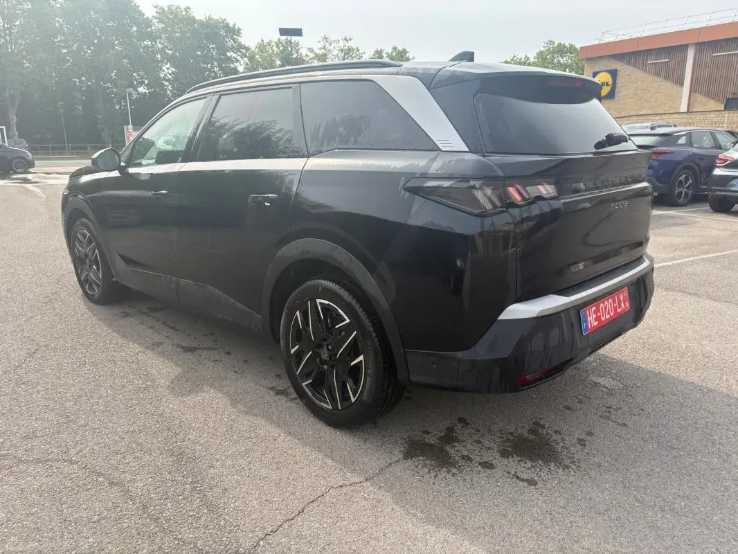 Peugeot 5008 Hybrid noir en 3/4 arrière droit, avec jantes alliage et feux arrière LED distinctifs.