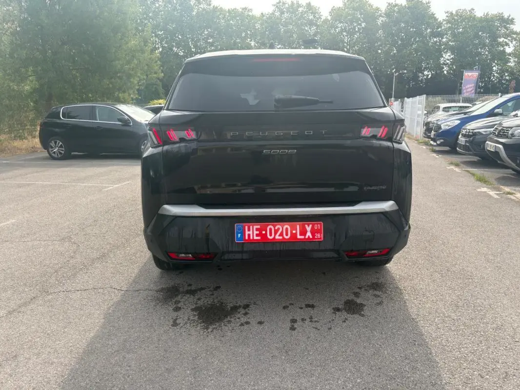 Vue arrière d'un Peugeot 5008 noir 2025 Hybrid 145 ch avec feux arrière distinctifs et plaque d'immatriculation rouge.