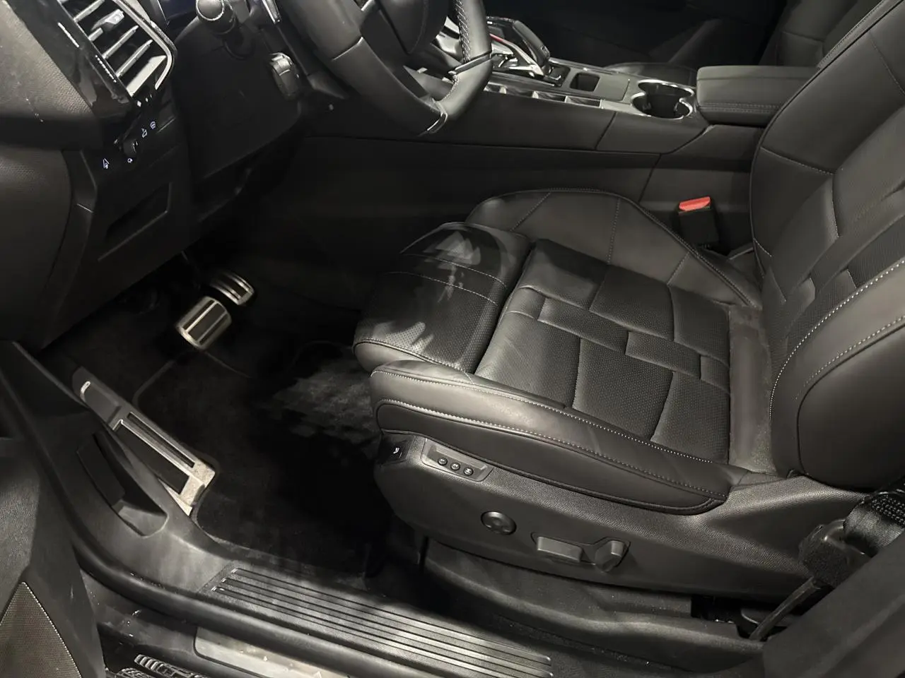 Vue intérieure côté conducteur du siège avant en cuir noir du DS7 Crossback 2025 avec réglages électriques et console centrale visible.