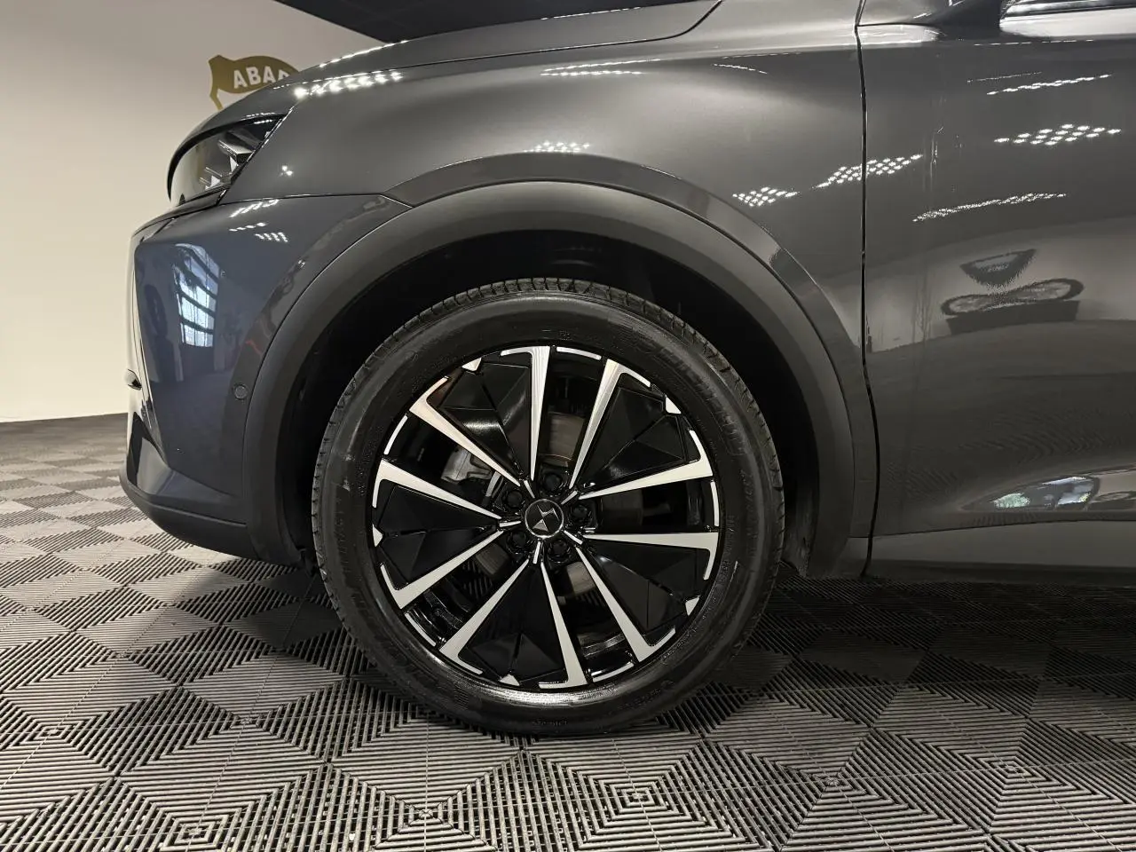 Gros plan sur la roue avant gauche du DS7 Crossback gris métallisé avec jante alliage 19'' Edinburgh bicolore.