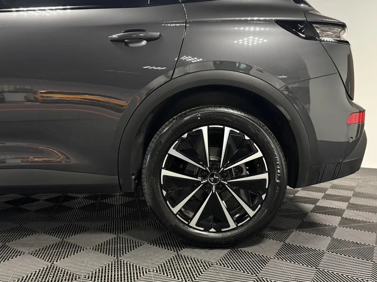 Vue latérale arrière droite du DS7 Crossback gris métallisé, mettant en valeur la jante alliage 19'' Edinburgh noire et argent.