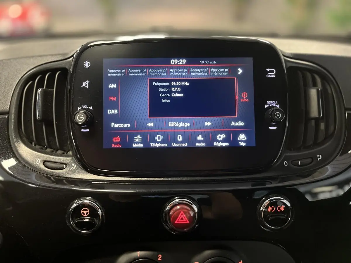 Écran tactile central allumé du tableau de bord noir brillant de la Fiat 500 Dolcevita 2023, vue frontale rapprochée.