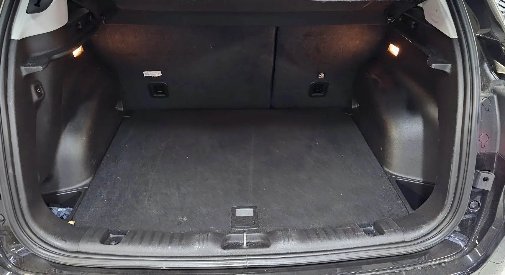 Coffre ouvert noir du Jeep Compass 2023, vue arrière montrant l'espace de chargement et l'éclairage intérieur.