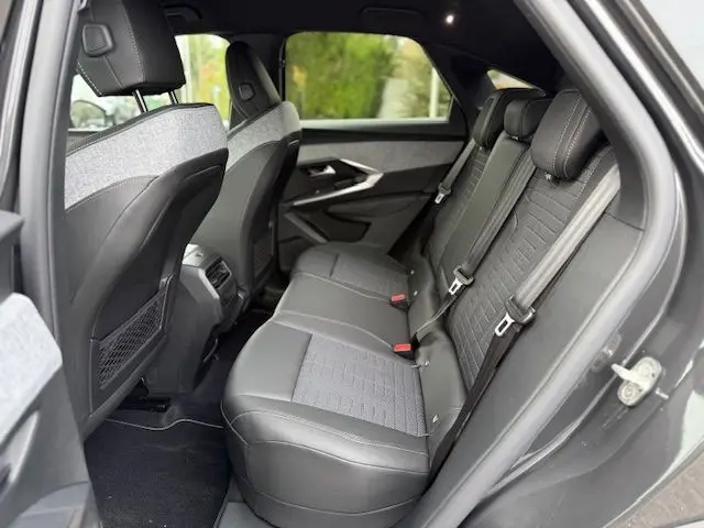 Vue latérale intérieure arrière du Peugeot 3008 Hybrid 145 GT gris titane, avec sellerie tissus Uziris et TEP, sièges arrière 3 places.