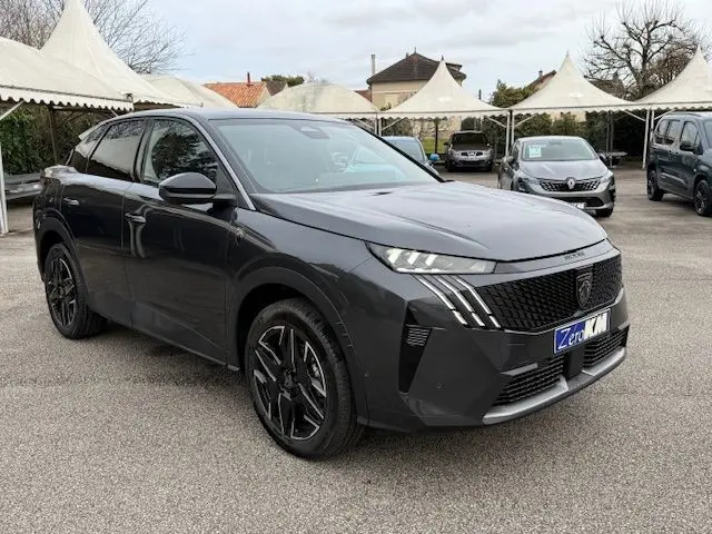 PEUGEOT 3008 HYBRID 145 GT gris titane en 3/4 avant droit avec jantes alliage noires et calandre distinctive.